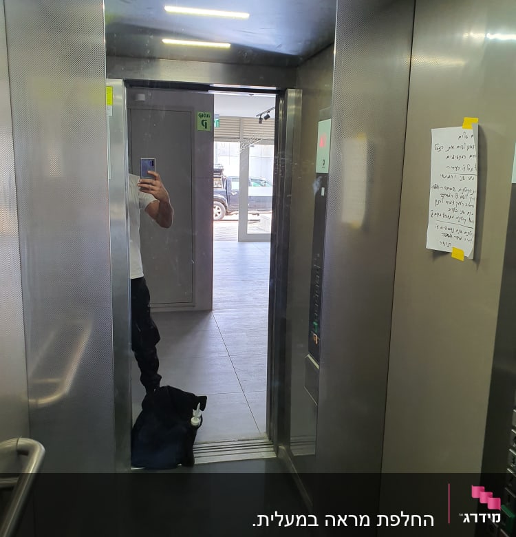 מראה זכוכית במעלית עם השתקפות אדם